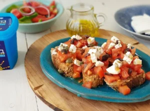 Toasted Baguette Topped with Tomatoes, Olives, Capers and Feta Delight